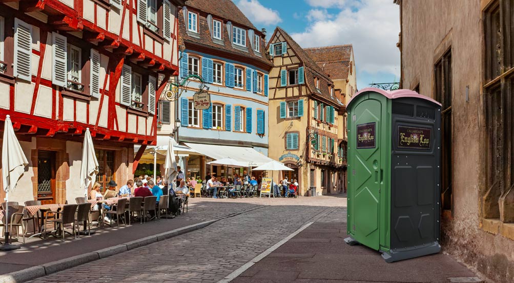 English Loo  | English Loo on the sidewalk in a city, with outdoor dining across the street.