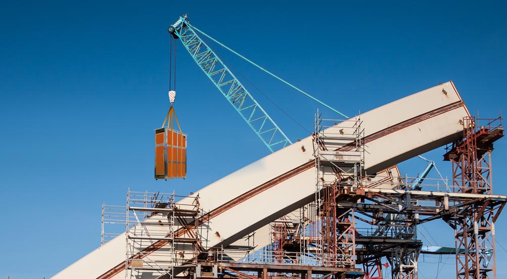 Skycrapper Portable Restroom | Orange Colored Skycrapper Portable Toilet Being Hoisted by a Crane to a Jobsite